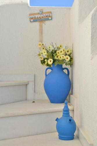 a blue vase with a bouquet of flowers in it at Theoni Studios in Kastraki Naxou
