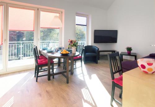 una sala da pranzo con tavolo, sedie e televisione di Apartment11 Wartburg a Colonia