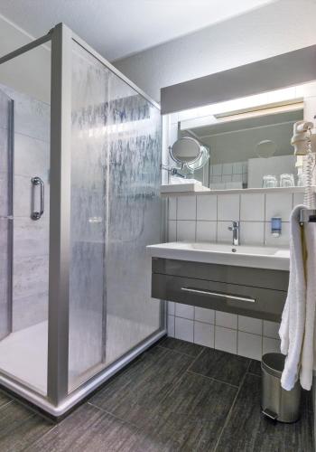 a bathroom with a shower and a sink at Hotel-Restaurant Kämper Superior in Bad Zwischenahn