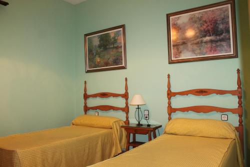 a bedroom with two beds and a table with a lamp at Alojamiento rural El Salto in Villafranca de Córdoba
