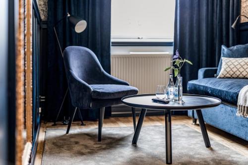 a living room with a chair and a table at Hällsnäs Hotell & Restaurang in Mölnlycke