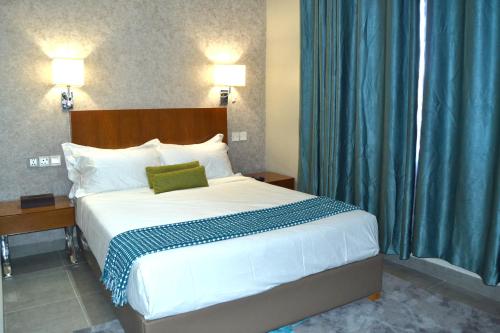 1 dormitorio con 1 cama grande y cortinas azules en Phudzi Hotel, en Letlhakawe