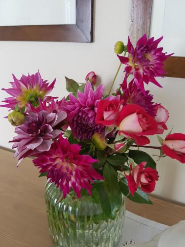 a vase filled with pink flowers on a table at Foresteria Villa Margherita in Colico