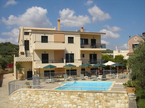 un edificio con piscina frente a un edificio en Irida Apartments -EX BLAZIS HOUSE, en Almyrida