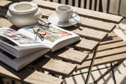 a book and glasses on a table with a cup of coffee at Bed & Breakfast AMATI in Fasano
