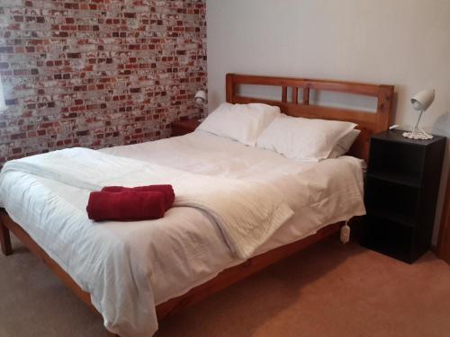 Un dormitorio con una cama con una toalla roja. en Riversong en Ohakune