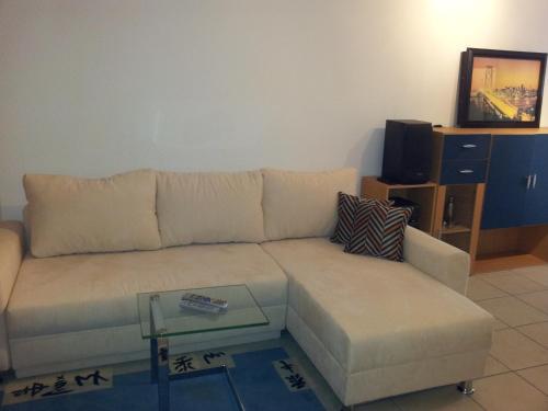 a living room with a couch and a glass table at Hotel Wippertal - voll klimatisiert in Bernburg