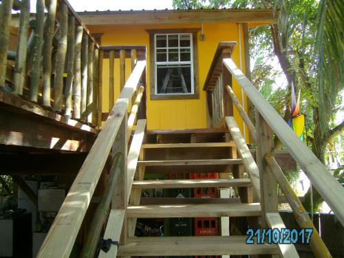 a staircase leading up to a yellow house at The Funky Dodo Backpackers Hostel in Hopkins