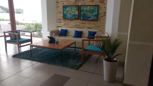 a living room with a couch and two chairs at Departamento Peñuelas Sol Marina III La Serena - Coquimbo in Coquimbo