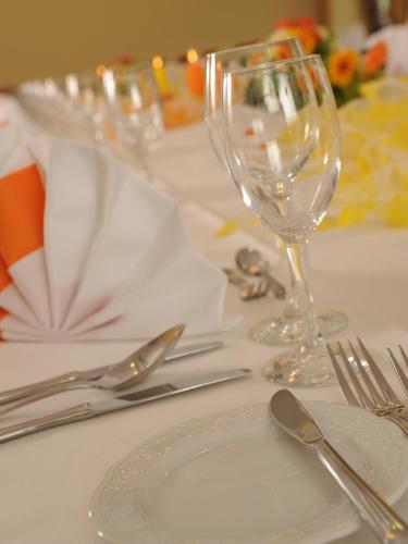 a table with a plate and wine glasses on it at City Partner Hotel Strauss in Würzburg