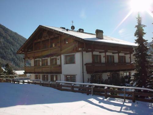 a large wooden house with snow on the ground at Residence Grünwald in Valles