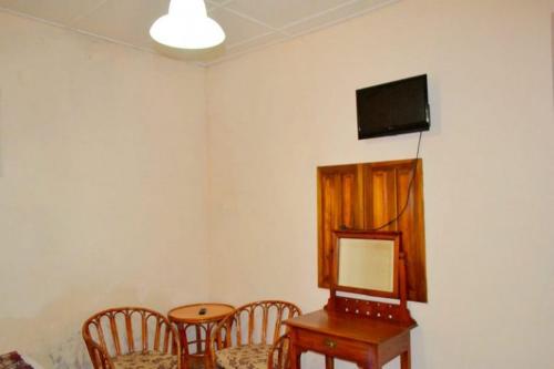 a room with a table and chairs and a television on the wall at Highcliffe Guest House in Haputale