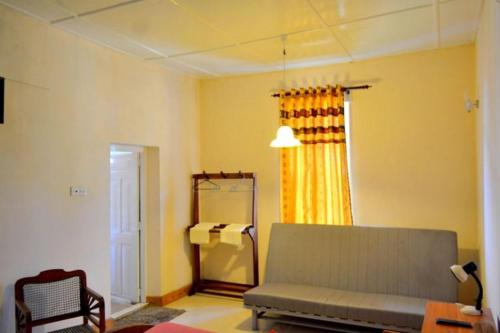 a living room with a couch and a window at Highcliffe Guest House in Haputale