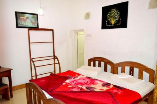 a bedroom with a bed with a red blanket at Highcliffe Guest House in Haputale