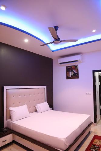 a bedroom with a bed with a ceiling fan at Hotel Dhanraj Palace in Bharatpur