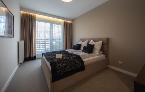a bedroom with a bed and a large window at Mariacka Old Town Apartments in Szczecin