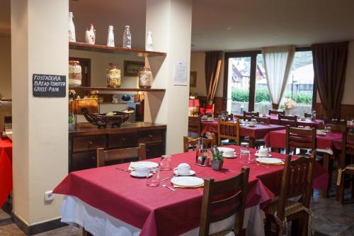 a dining room with tables with red table cloth at Aparthotel La Vall Blanca in Vielha