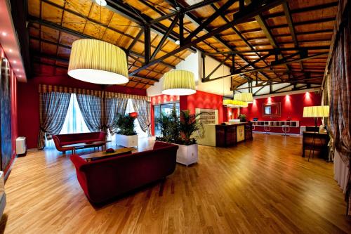 a large living room with red walls and wooden floors at Hotel Villa Sturzo in Caltagirone