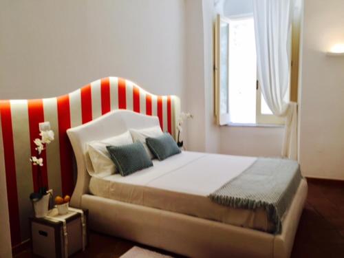 a bedroom with a bed with a red and white headboard at S'O Smart B&B Tropea in Tropea
