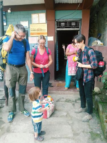 a group of people standing around a little boy at Bandipur Samira Homestay & Mountain View Restaurant in Bandīpur