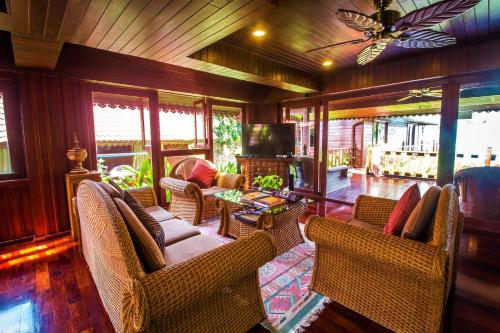 a living room with wicker chairs and a table at Erawan Villa Hotel in Bangrak Beach