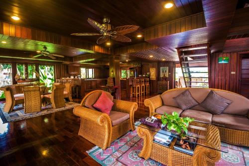 a living room with a couch and chairs and a table at Erawan Villa Hotel in Bangrak Beach