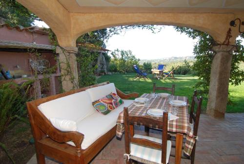 a patio with a white couch and a table with a tableablish at B&B La Murichessa in Arzachena