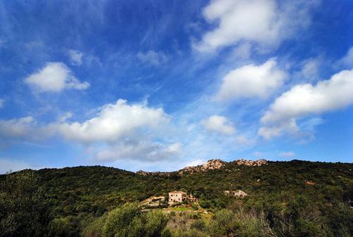 a house on top of a mountain with a blue sky at B&B La Murichessa in Arzachena