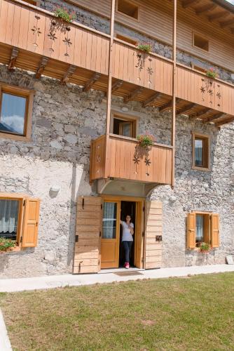 a woman standing in the doorway of a building at Albergo Diffuso Dolomiti in Forni di Sotto