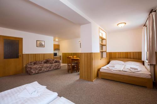 a hotel room with two beds and a table at Penzion Barborka in Rokytnice nad Jizerou