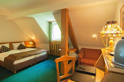 una camera con letto, scrivania e sedia di Hotel Allegro a Colonia