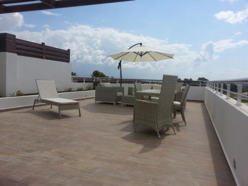 a patio with a table and chairs and an umbrella at Luxe Residence penthouse met dakterras in Side