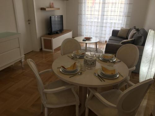 un soggiorno con tavolo, sedie e divano di Apartment Posejdon a Belgrado