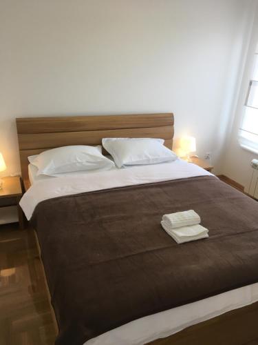une chambre avec un grand lit avec deux serviettes dessus dans l'établissement Apartment Posejdon, à Belgrade