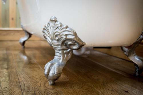 a silver leg of a table on a wooden floor at Lake Vyrnwy Hotel & Spa in Llanwddyn