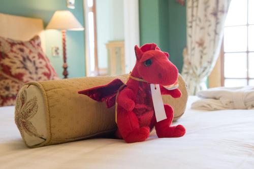 a red stuffed horse sitting on top of a bed at Lake Vyrnwy Hotel & Spa in Llanwddyn
