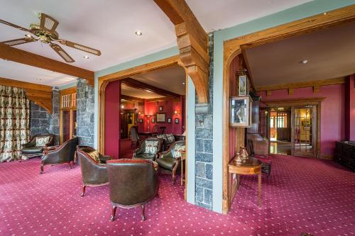 a living room with chairs and tables and a ceiling at Lake Vyrnwy Hotel & Spa in Llanwddyn