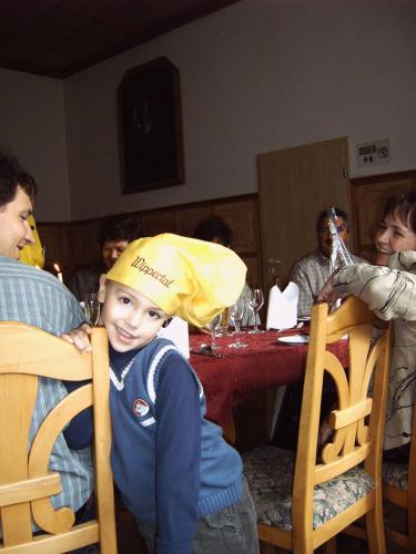 a young boy wearing a yellow hat at a table at Hotel Wippertal - voll klimatisiert in Bernburg