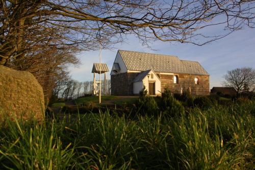 an old barn and a windmill in a field at Bed and Breakfast Lemvig in Lemvig