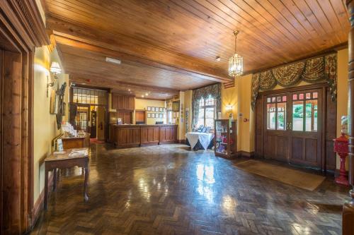 a large room with a wooden ceiling and a kitchen at Lake Vyrnwy Hotel & Spa in Llanwddyn