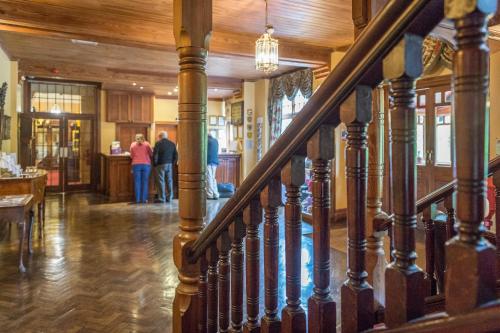 a staircase in a house with people walking around at Lake Vyrnwy Hotel & Spa in Llanwddyn