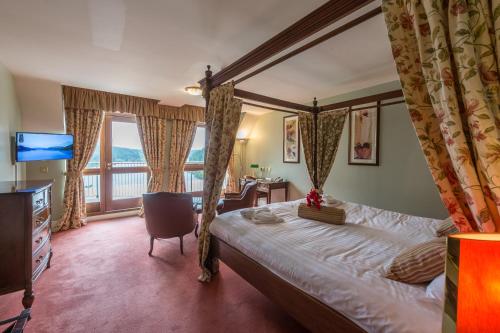 a bedroom with a bed and a large window at Lake Vyrnwy Hotel & Spa in Llanwddyn