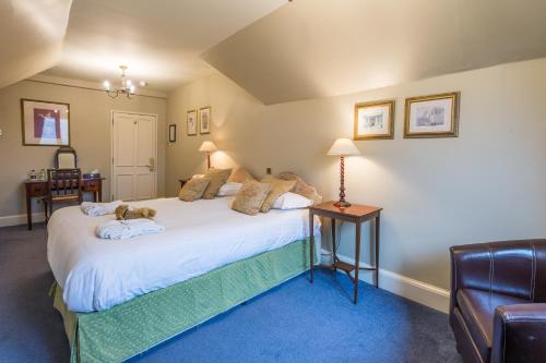 a bedroom with a bed and a couch at Lake Vyrnwy Hotel & Spa in Llanwddyn