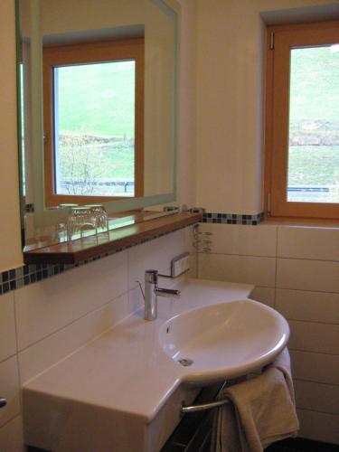 a white sink in a bathroom with two windows at Appartement Ronacher in Mittersill