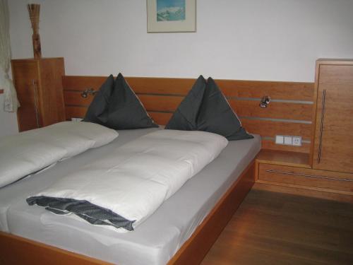 a bed with two pillows on top of it at Appartement Ronacher in Mittersill