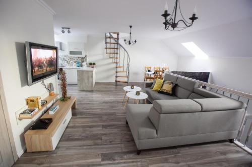 a living room with a couch and a tv at Apartamenty Kowary in Kowary