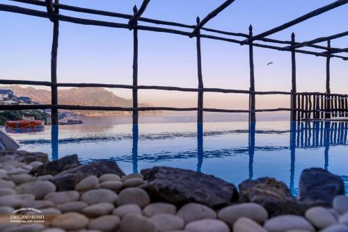 a pool of water with rocks and a body of water at Villa Alba d'Oro in Amalfi