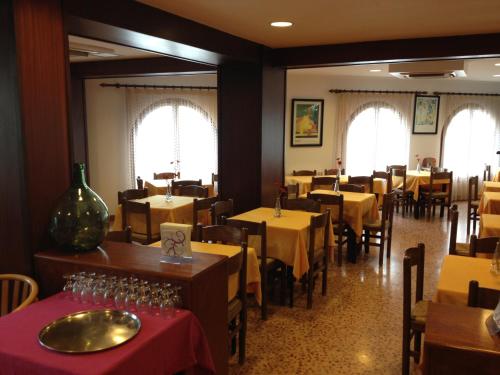 ein Esszimmer mit Tischen und Stühlen sowie einem gelben Tischtuch in der Unterkunft Hotel Ubaldo in Cadaqués