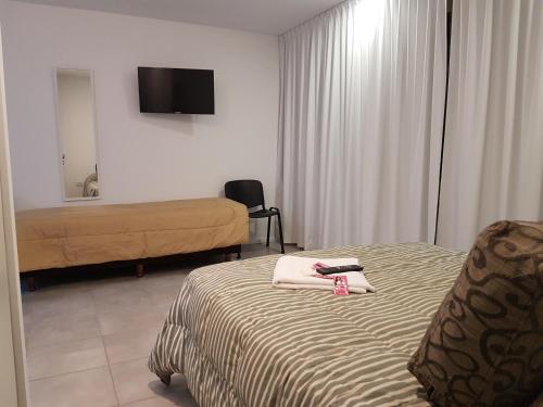 Habitación de hotel con cama y TV en Apartamento La Plata en La Plata