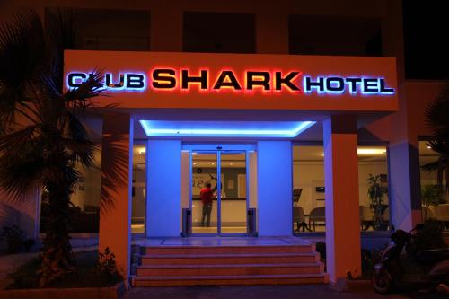 a sign for a shark hotel at night at Club Shark Hotel in Gümbet